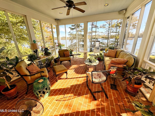 sunroom featuring a water view, brick flooring, and recessed lighting