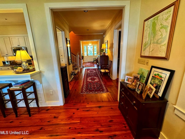 hallway with hardwood / wood-style flooring and ornamental molding