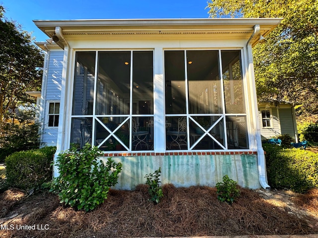 view of property exterior with a sunroom