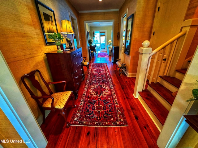 hall with dark wood finished floors, stairs, and baseboards