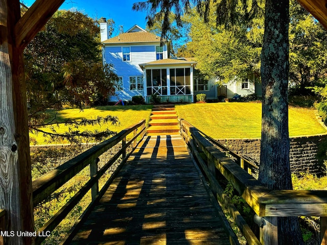 back of house featuring a lawn and a sunroom