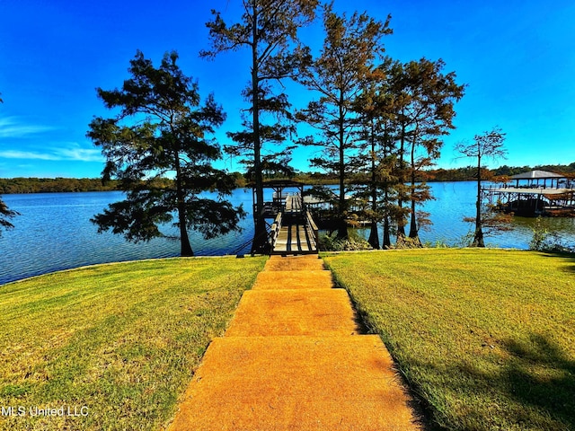 dock area with a water view and a yard