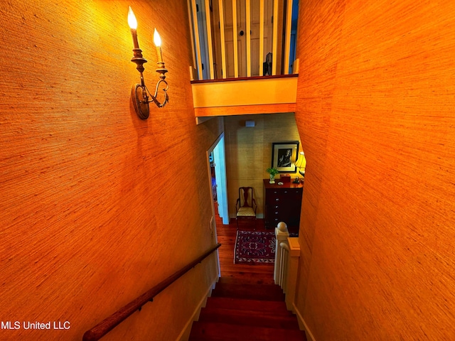 stairway featuring hardwood / wood-style floors and wooden walls