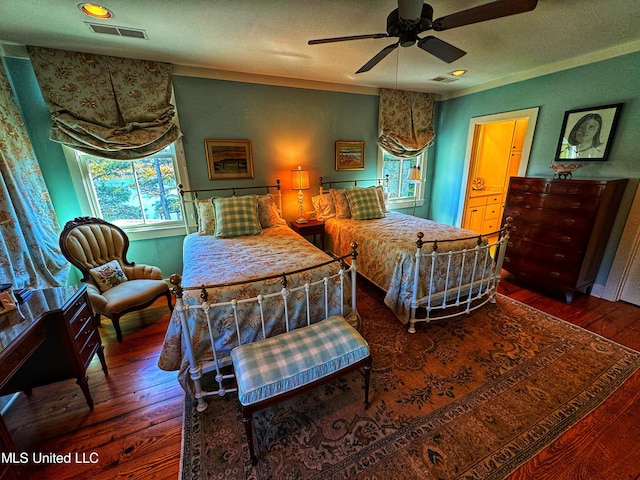 bedroom featuring a textured ceiling, dark hardwood / wood-style floors, and ceiling fan