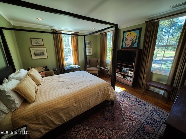 bedroom with crown molding and dark hardwood / wood-style floors