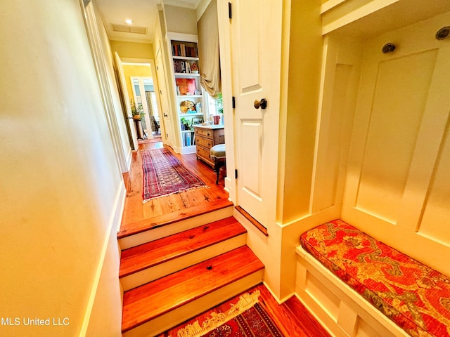 mudroom featuring wood finished floors, baseboards, and crown molding