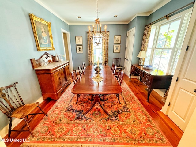 dining room featuring a chandelier, wood finished floors, ornamental molding, and baseboards