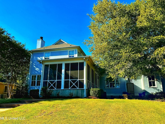 back of house with a yard and a sunroom