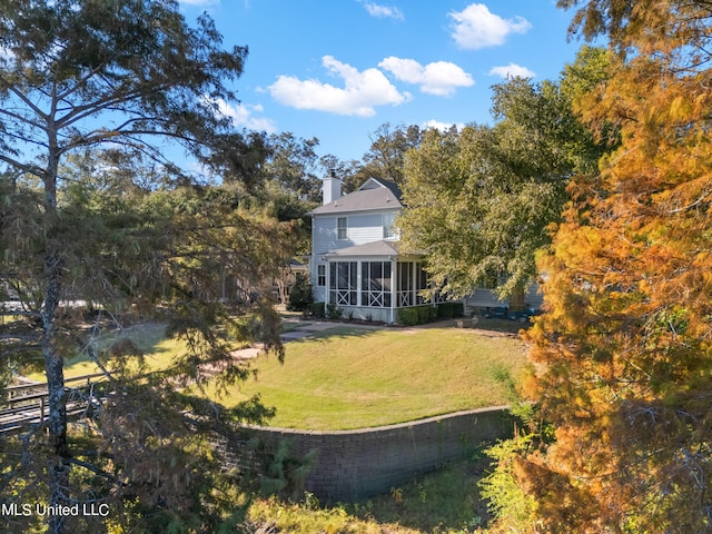 view of green lawn with a sunroom
