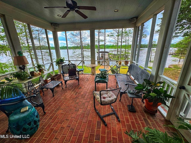 sunroom with a water view and ceiling fan