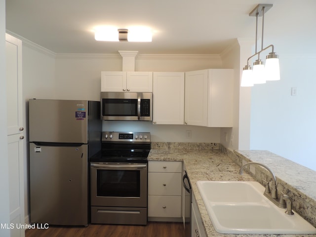 kitchen with stainless steel appliances, a sink, white cabinets, and crown molding