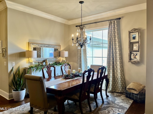 dining area featuring hardwood / wood-style flooring, an inviting chandelier, and crown molding