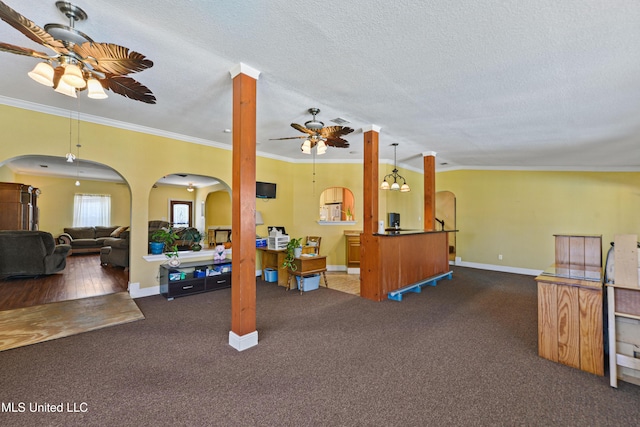 living area featuring a textured ceiling, arched walkways, a ceiling fan, and ornamental molding