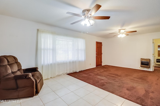 living room with ceiling fan, light colored carpet, and heating unit