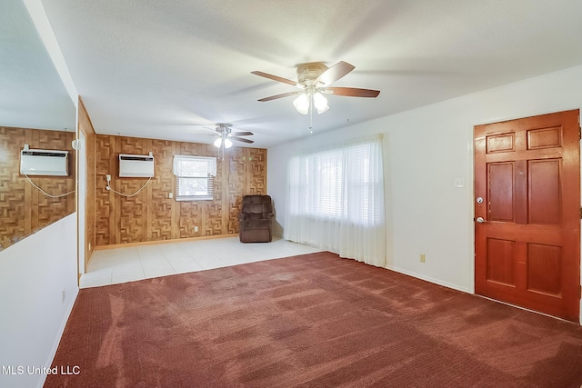 unfurnished living room featuring a healthy amount of sunlight, light colored carpet, and wood walls