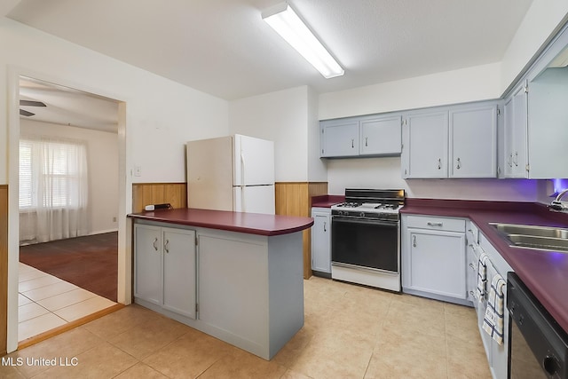 kitchen with sink, dishwasher, white fridge, light tile patterned floors, and range with gas stovetop