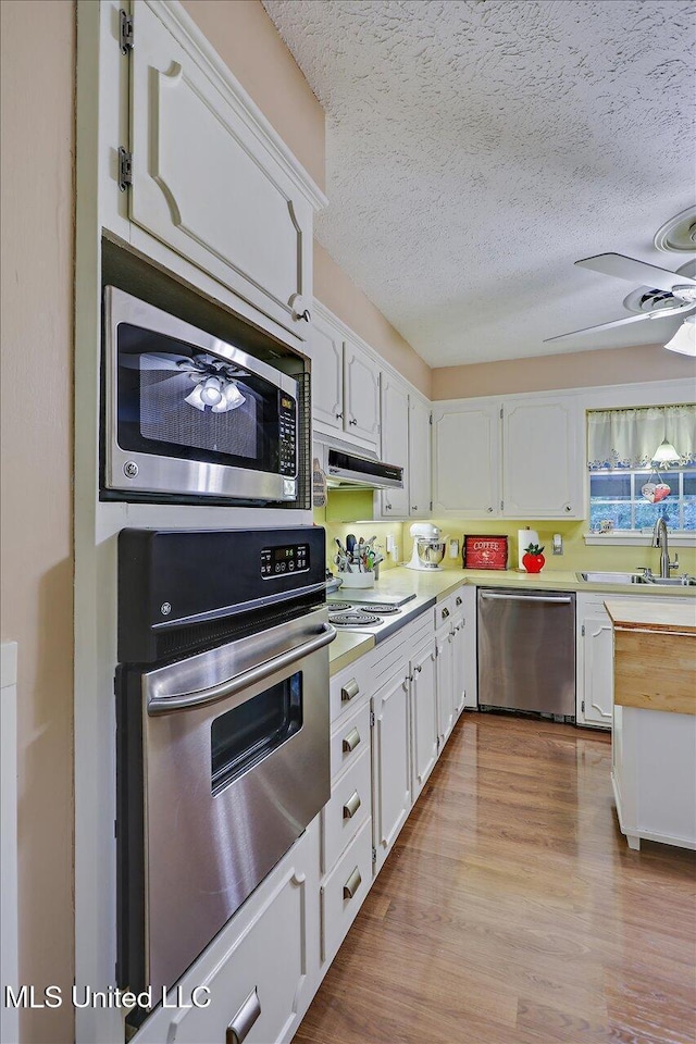 727 Laney Dr, Clinton, MS 39056 - kitchen with appliances with stainless steel finishes, a ceiling fan, white cabinets, a textured ceiling, and a sink