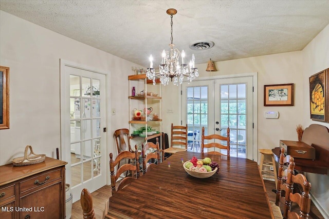 727 Laney Dr, Clinton, MS 39056 - dining room with french doors, a chandelier, wood finished floors, and a textured ceiling