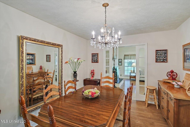 727 Laney Dr, Clinton, MS 39056 - dining area with light wood finished floors, a chandelier, and a textured ceiling