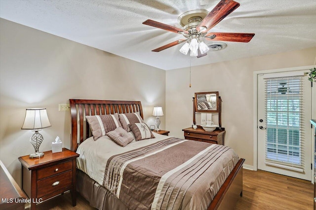 727 Laney Dr, Clinton, MS 39056 - bedroom featuring wood finished floors, access to exterior, a textured ceiling, baseboards, and ceiling fan