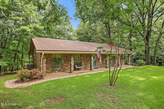 727 Laney Dr, Clinton, MS 39056 - view of front of home with a front yard, metal roof, and central AC unit