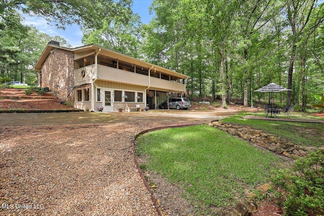 727 Laney Dr, Clinton, MS 39056 - back of house featuring driveway, a chimney, and a balcony