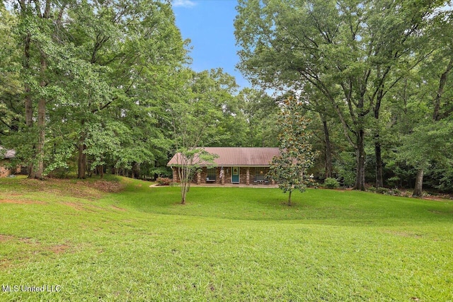 727 Laney Dr, Clinton, MS 39056 - view of front facade featuring a front yard, metal roof, and a view of trees