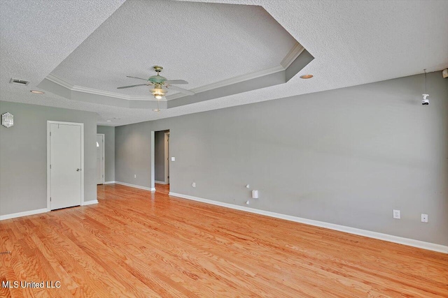 unfurnished room with light hardwood / wood-style floors, a textured ceiling, ceiling fan, and a raised ceiling