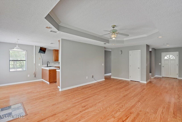 unfurnished living room with sink, ceiling fan, light hardwood / wood-style floors, and a raised ceiling