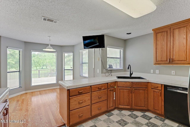 kitchen featuring kitchen peninsula, dishwasher, a healthy amount of sunlight, and sink