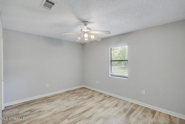 empty room featuring ceiling fan, a textured ceiling, and light wood-type flooring