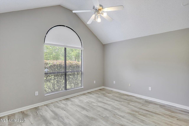 empty room featuring lofted ceiling, light hardwood / wood-style flooring, a textured ceiling, and ceiling fan