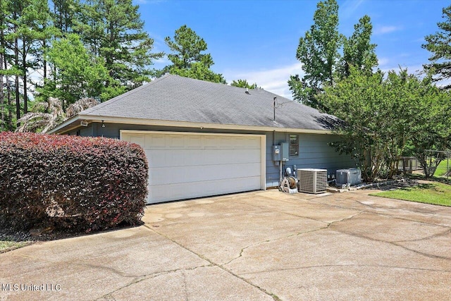 view of front of property with central AC unit and a garage