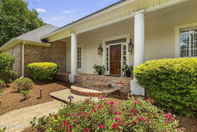 141 Whisper Lake Blvd, Madison, MS 39110 - doorway to property featuring covered porch, brick siding, and a shingled roof