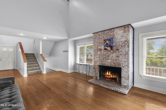 107 Lakepointe Dr, Madison, MS 39110 - unfurnished living room with baseboards, wood finished floors, a fireplace, stairway, and lofted ceiling