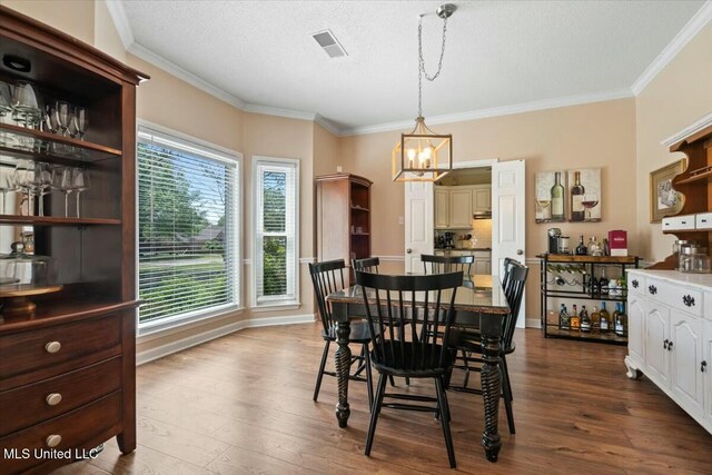 8538 Collinswood Dr, Olive Branch, MS 38654 - dining room featuring crown molding, visible vents, a notable chandelier, and dark wood-type flooring