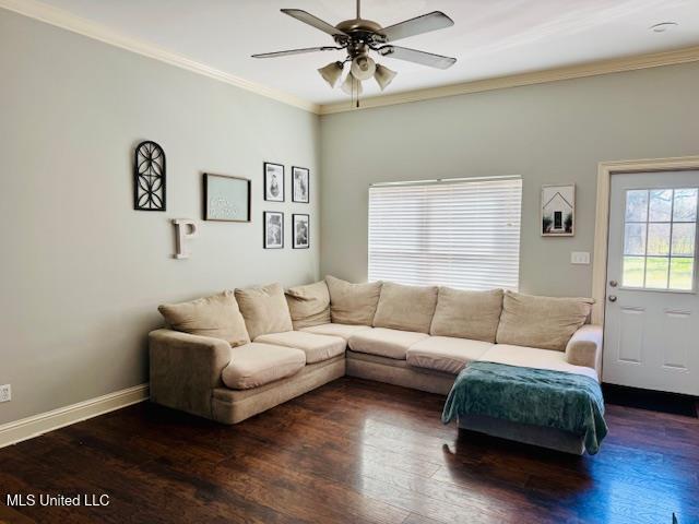 living area featuring a ceiling fan, baseboards, ornamental molding, and wood finished floors