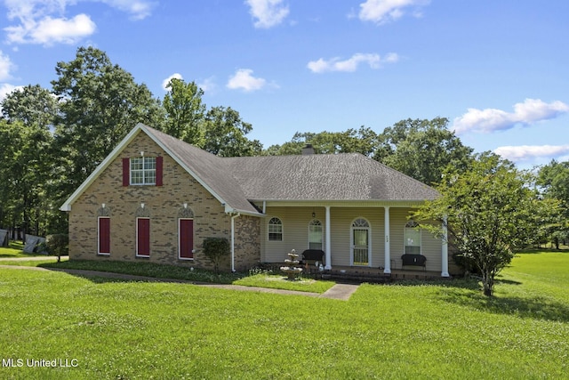 view of front of house featuring a front yard, a chimney, and a shingled roof