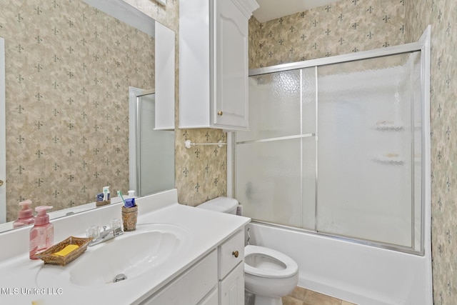 bathroom featuring wallpapered walls, toilet, vanity, enclosed tub / shower combo, and tile patterned flooring
