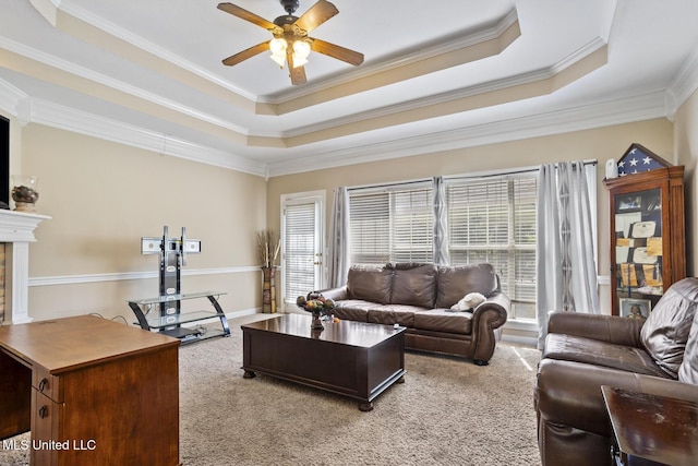 living room with light colored carpet, healthy amount of natural light, a raised ceiling, crown molding, and ceiling fan