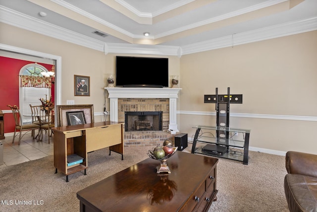 carpeted living area featuring a raised ceiling, a fireplace, ornamental molding, and baseboards