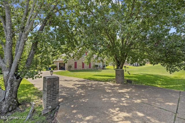 view of front of house featuring an attached garage, a front lawn, and driveway