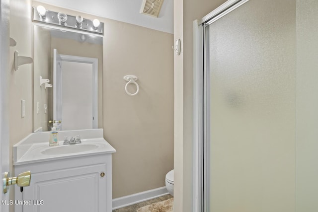 bathroom with toilet, vanity, and a shower stall