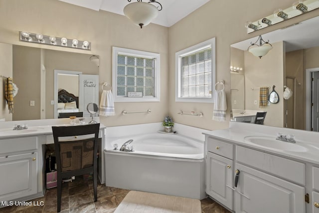 full bathroom featuring two vanities and a garden tub