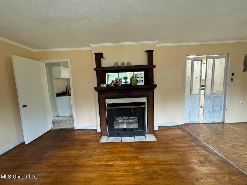 unfurnished living room featuring crown molding, wood-type flooring, and a textured ceiling