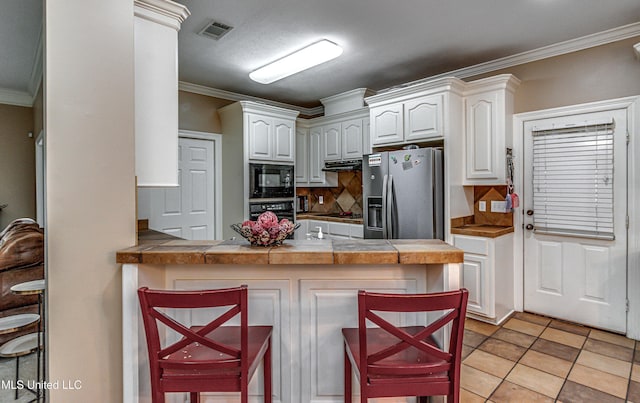350 Edgewood Xing, Brandon, MS 39042 - kitchen with black appliances, ornamental molding, a peninsula, a kitchen bar, and tasteful backsplash