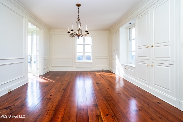 unfurnished dining area with a notable chandelier, ornamental molding, and dark wood-type flooring