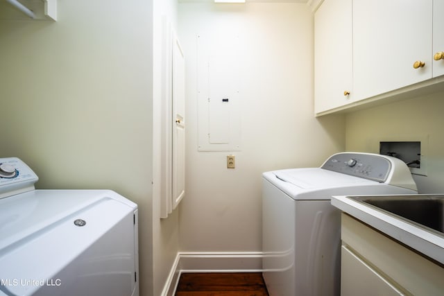laundry area featuring washing machine and clothes dryer, cabinet space, baseboards, and wood finished floors