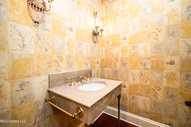 bathroom featuring tile walls, wood finished floors, and a sink