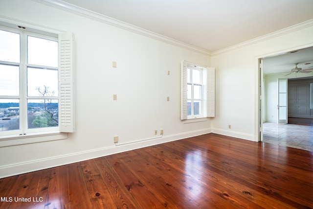 empty room with ornamental molding, dark wood-type flooring, ceiling fan, and plenty of natural light